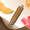 A stylised image featuring a melon vape pen surrounded by slices of melon, cubes of watermelon, and a textured brown background.