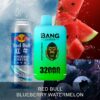A can of Red Bull energy drink is displayed next to a green vape device labeled "BANG LEADER" with a gorilla graphic, featuring a flavor combination of "Red Bull & Blueberry Watermelon" and "32,000 PUFFS" text. The background includes watermelon slices and blueberries.