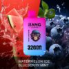 A vibrant vape product packaging featuring a cartoon monkey wearing glasses, surrounded by splashes of watermelon and blueberries, with "BANG LEADER" and "32000 PUFFS" written on it, highlighting the flavors "WATERMELON ICE" and "BLUEBERRY MINT".