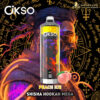 A stylised vape device with transparent body showing fiery internal design, labeled 'OKSO', set against an illustrated male figure with blue and orange hair and beard, wearing round yellow-tinted glasses. The background features mystical golden symbols and scripts on black. Two peaches and the text 'PEACH ICE SHISHA HOOKAH MEGA' appear near the bottom, with brand logos 'OKSO' and 'DOGEVAPE' at the top.