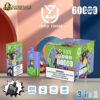 Disposable vape device and packaging in green and purple colors featuring a cartoon monkey wearing sunglasses and a hat, branded "Uzy" with 600 puffs indicated, alongside warnings about nicotine addiction and icons for triple mesh coil, 54ml capacity, 850mAh battery, and Type-C port.