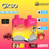 Promotional image featuring the 'OKSO Double Flavor' vape device, showing its vibrant pink and yellow design, flavors Cherry Fiesta and Strawberry Banana, key features like 60000 puffs, 2x25ml oil tank, and 650mAh battery, with added graphic elements showcasing cherries and strawberries.